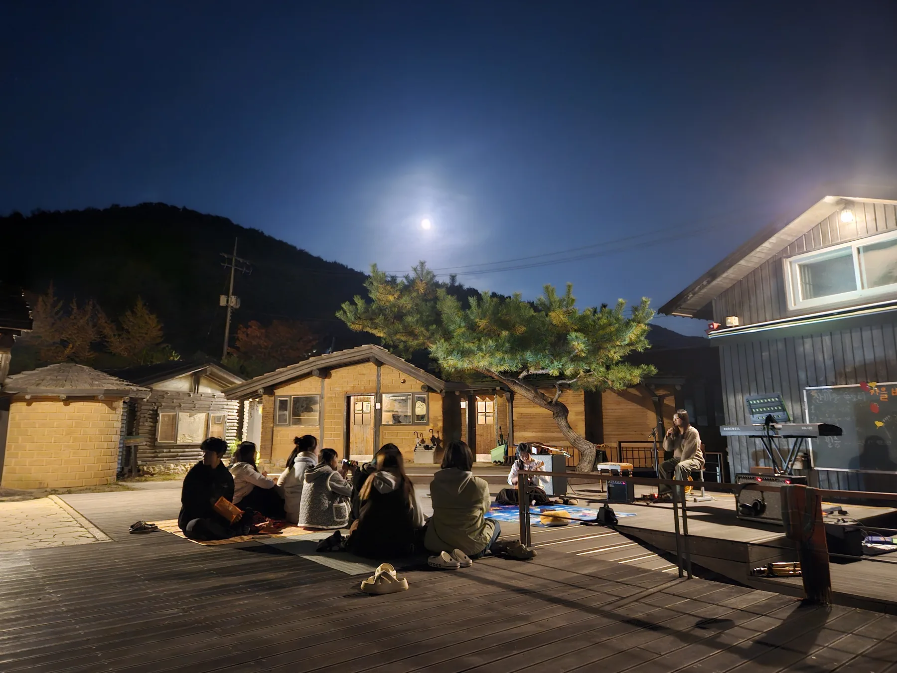 밤이 된 학교 뜰에 둘러앉아 시간을 보내는 학생들